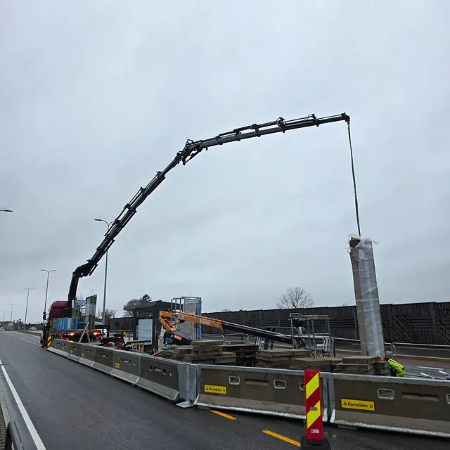 Rød kranbil under oppdrag i veioppdrag